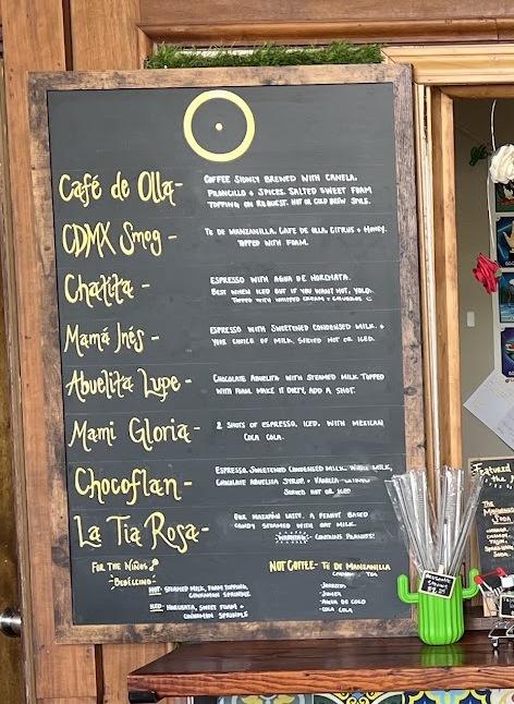 The chalkboard drink board at Café Ollama, hand lettered in yellow and white.